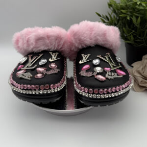 A pair of black, pink fur-lined clogs adorned with designer-inspired charms and pink and clear rhinestones.