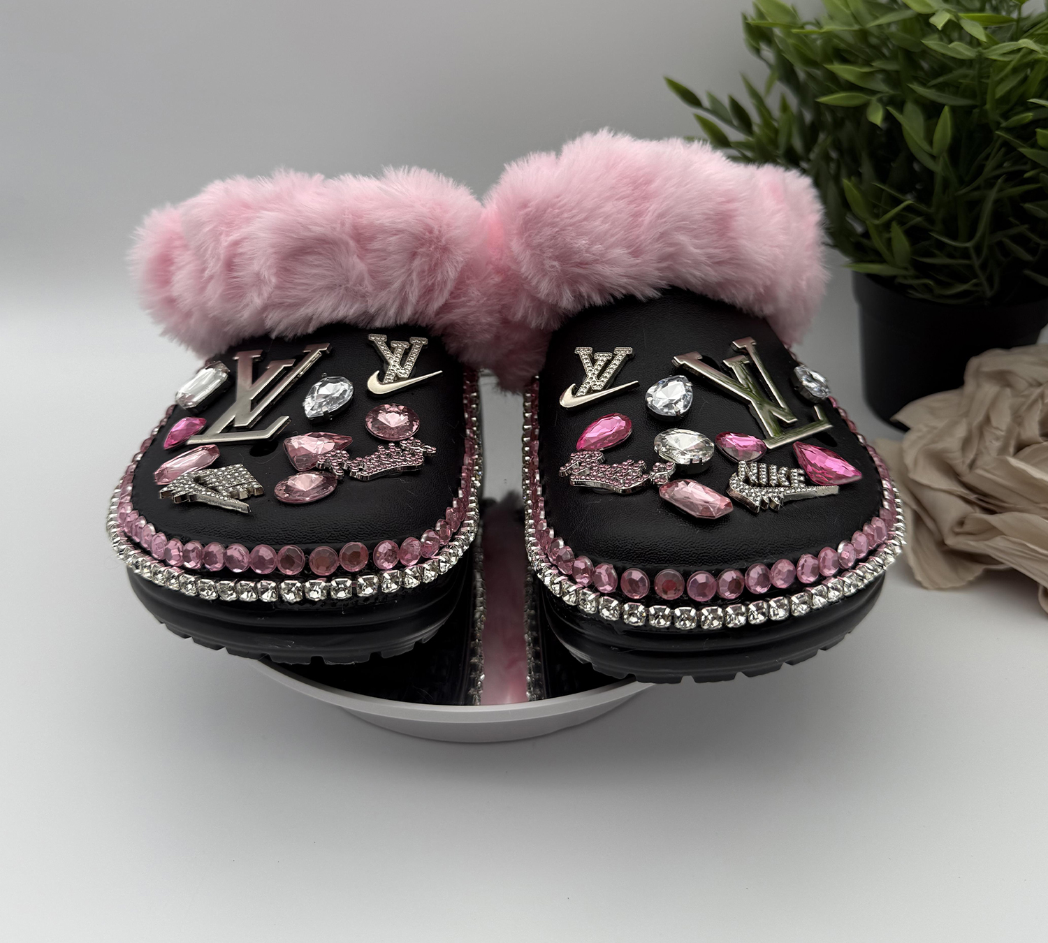 BLAFURCR-032 A pair of black, pink fur-lined clogs adorned with designer-inspired charms and pink and clear rhinestones.