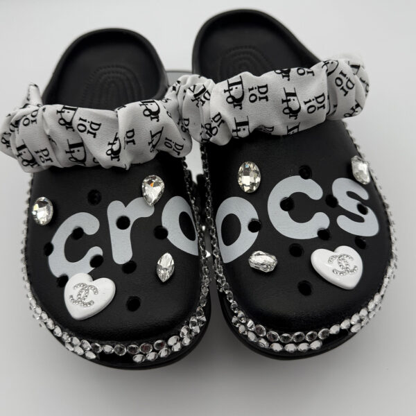 A pair of black custom Crocs with 