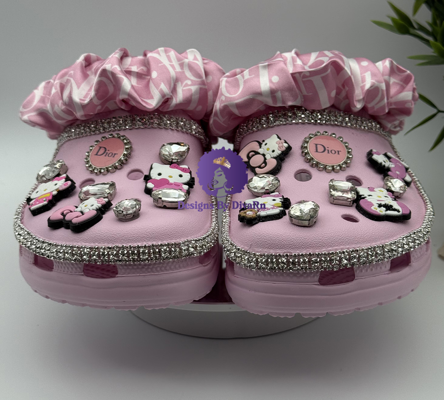 Pink clogs with crystals, Hello Kitty charms, and a pink ribboned scrunchie